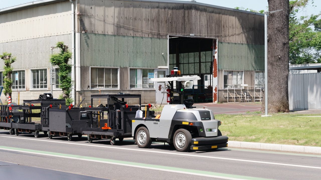 日立建機土浦工場、屋外自動搬送の導入事例を公開。4人工削減と作業負荷軽減を実現